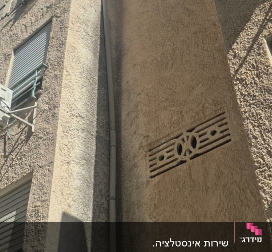 התקנת צינור צנרת חיצוני לאורך קיר של בניין מגורים